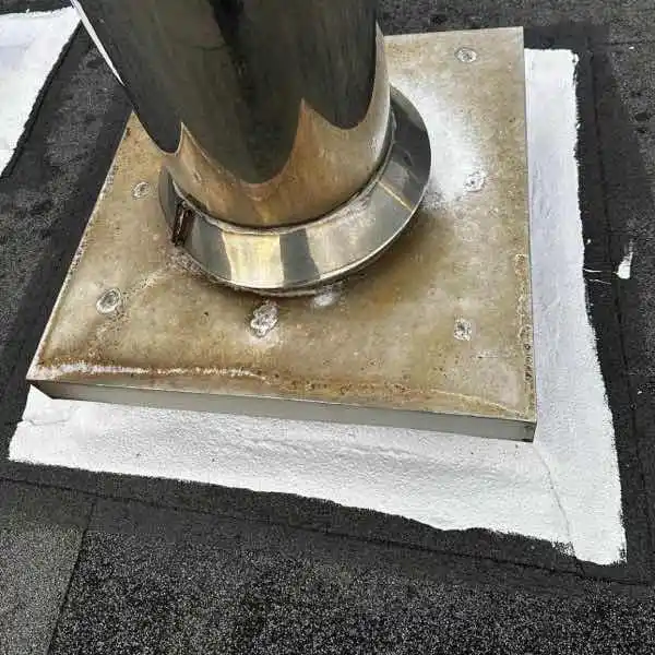Lava 20 waterproofing membrane applied to asbestos roof chimney flashing showing flexible coating bridging movement between masonry and roofing sheets