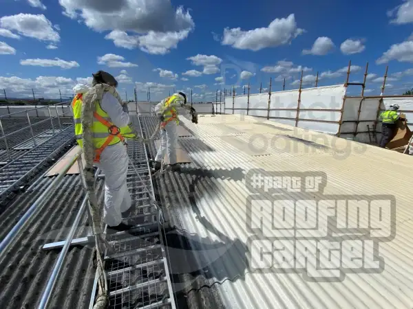 Spray foam insulation being applied to commercial building asbestos roof before Polyurea coating in Dublin
